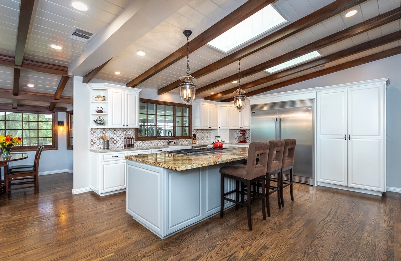Kitchen island with pro range and stacked stone fireplace — La Cañada
